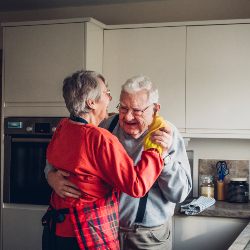 older man and woman dancing in kitchen