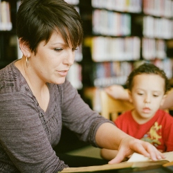 Woman teaching child to read