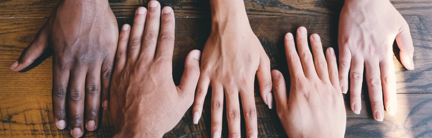 Five different shaped and coloured hands in a line - Photo by Clay Banks on Unsplash